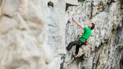 Mann klettert Steilwand hoch